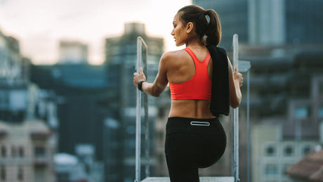 Fit woman resting on rooftop after workout.