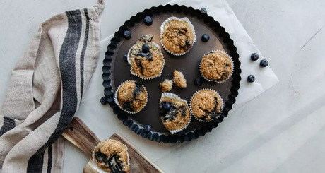 Homemade blueberry oat muffins arranged in a baking tin.