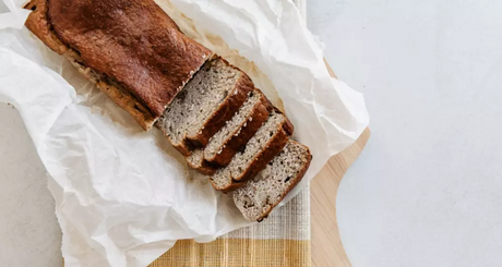 Pane proteico a fette su tagliere di legno.