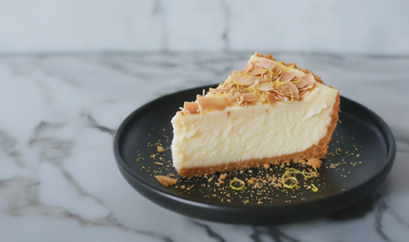 Slice of coconut lemon cake topped with coconut flakes on a plate