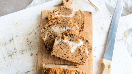 Saftiger Bananenkuchen mit Butter bestrichen auf Holzbrett.