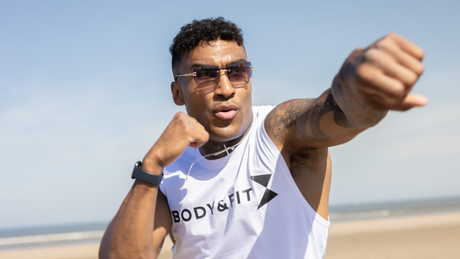 Homme boxant sur la plage en débardeur Body&Fit.
