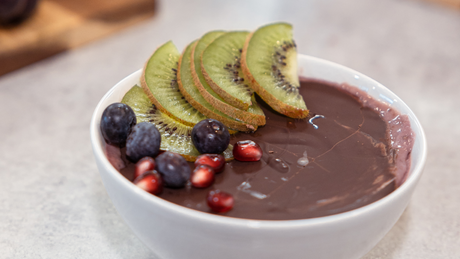 Chocolate protein smoothie bowl with kiwi and berries.