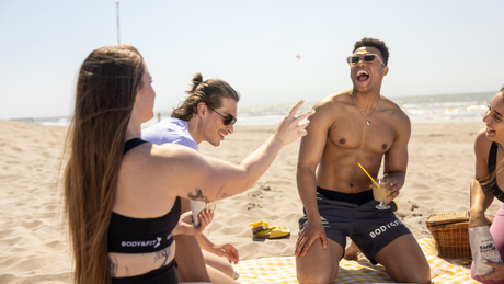 Groupe d’amis Body&Fit profitant d’un pique-nique à la plage.
