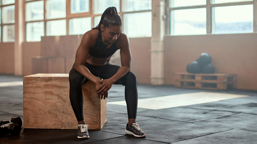Femme assise sur un box après un entraînement intensif.