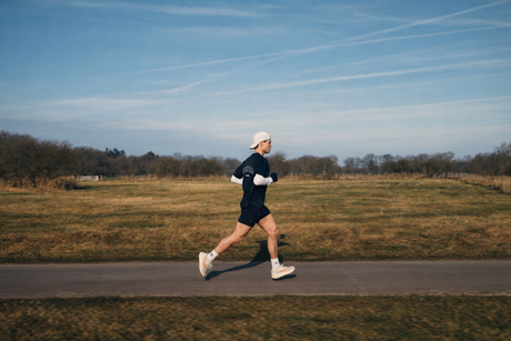 Man rent buiten op een weg in een open landschap, passend bij hybride sporten en duursport