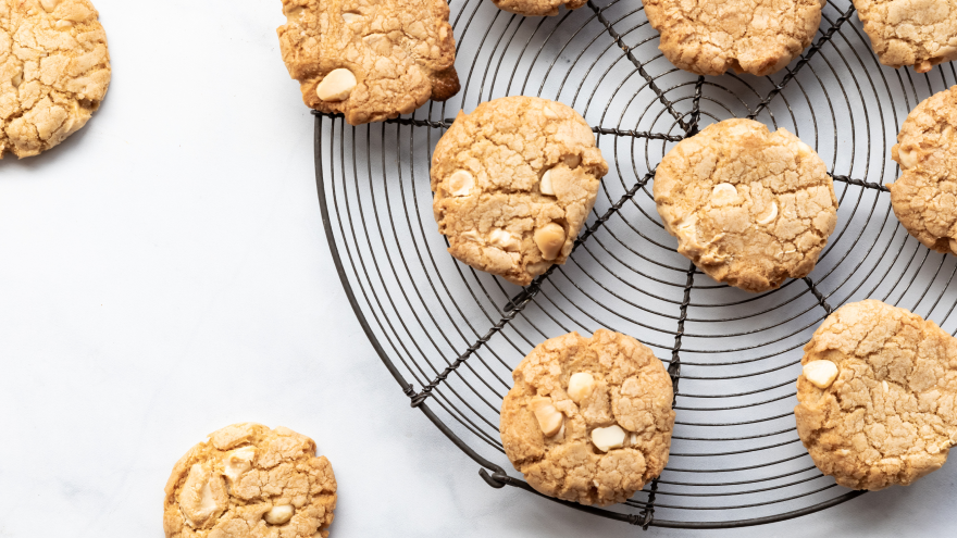 Koekjes met witte chocolade op rooster en marmeren achtergrond.