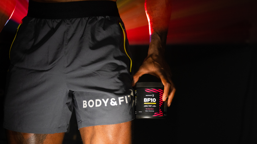 Man in Body&Fit short houdt pre-workout supplement vast.