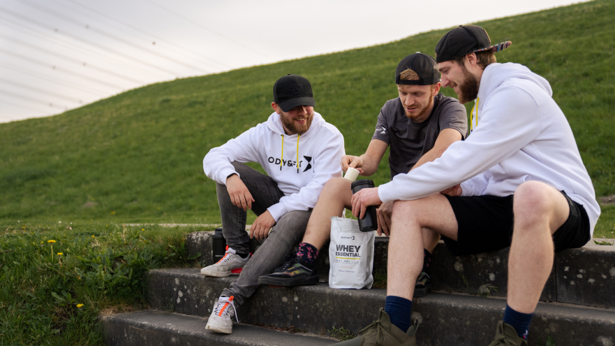 Trois amis assis discutant avec whey Body&Fit.