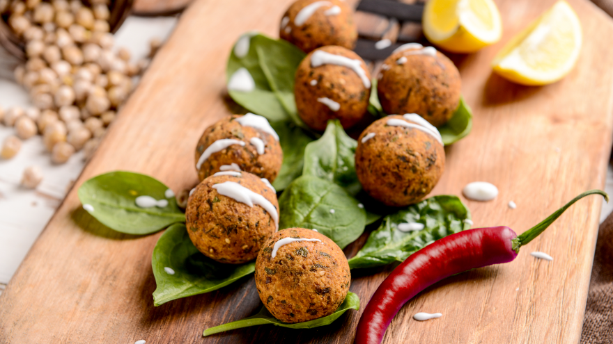 Boulettes végétariennes sur lit d’épinards avec piment rouge.