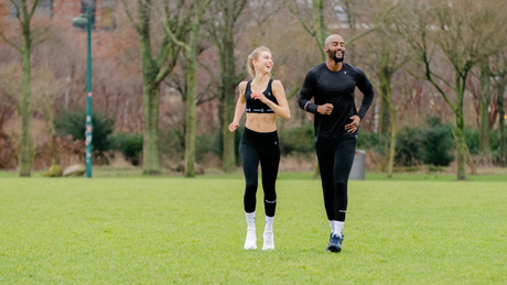 Couple en tenue de sport courant dans un parc.