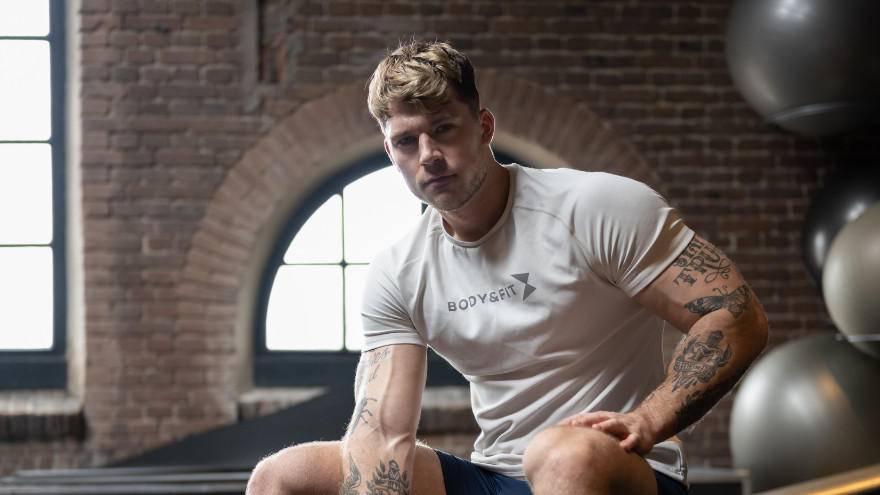 Homme musclé assis en salle de sport Body&Fit.