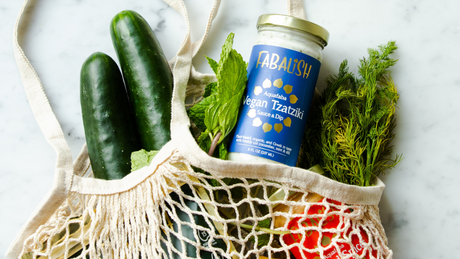 Herbruikbare tas met vegan tzatzikisaus en verse groenten.