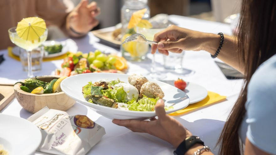 Vrouw eet gezonde lunch met salade en groenten.