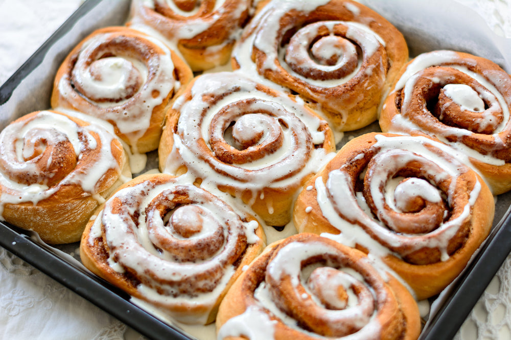 Brioches à la cannelle fraîchement sorties du four avec glaçage dans un plat de cuisson
