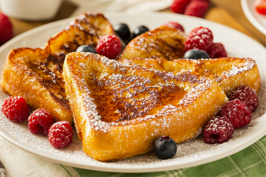 Plate of high protein French toast topped with powdered sugar and fresh berries