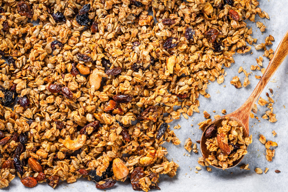 Gebakken granola met noten en rozijnen op bakplaat.