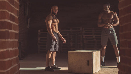 Twee mannen in gym klaar voor box jump workout.