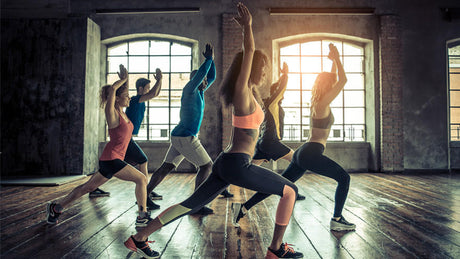 Groepsles fitness met lunges in sportstudio.